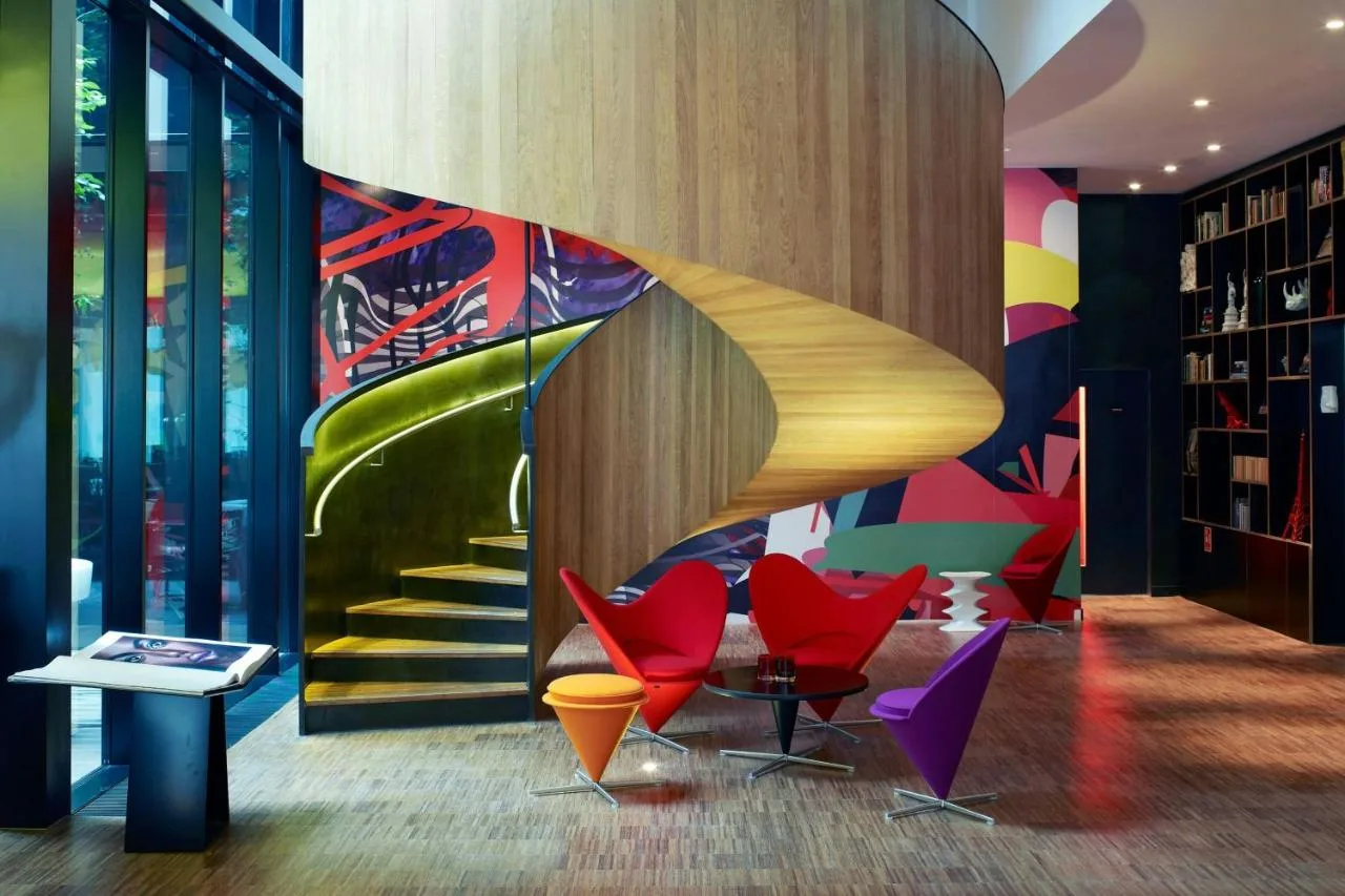 a lobby with colorful chairs and a staircase at citizenM London Bankside in London