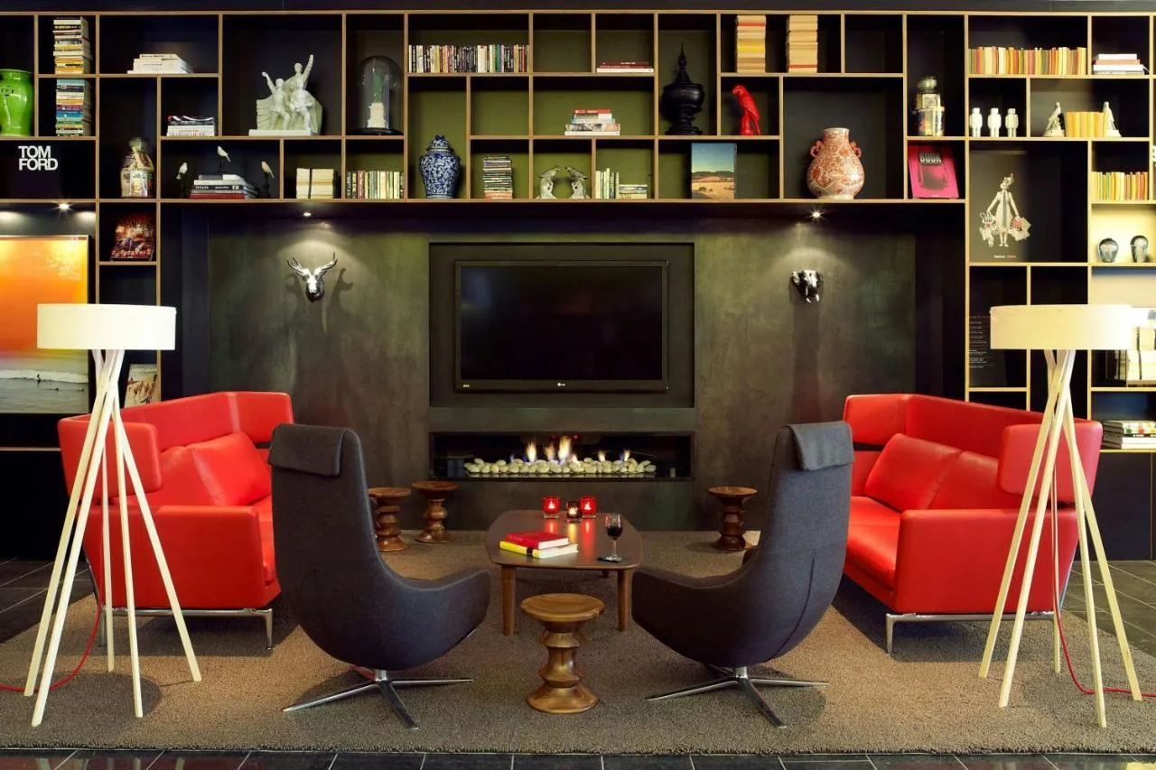 a living room with red furniture and a fireplace at citizenM London Bankside in London